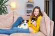 © Tatyana Gladskih - happy teenage girl looks at phone screen at home