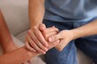 © New Africa - Son and his mother holding hands indoors, closeup