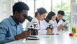 © Focus  - Four individuals using microscopes at lab table with colorful liquids and petri dishes—symbolizing hands-on scientific learning and research collaboration.