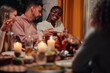 © Zamrznuti tonovi - Friends enjoying thanksgiving dinner with roasted turkey and candles