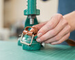 © Михаил Решетников - A woman attaches accessories to a leather belt. Leatherworker's workshop.
