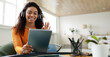 © Prostock-studio - Distance Education. Positive black lady wearing wireless headest at virtual meeting, sitting at desk, having video call on tablet, waving to webcam. Woman studying or teaching online at home, banner