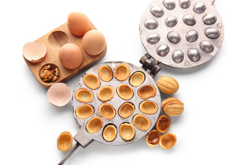 Wall Mural - Baking form with tasty walnut shaped cookies and eggs on white background
