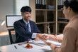 © Wasana - A man shakes hands with a woman in a business setting