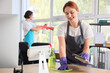 © Pixel-Shot - Female janitor cleaning desk in office