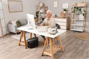 Senior programmer working at desk in office