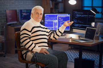 Senior programmer sitting in office at night