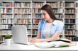 © BillionPhotos.com - Student typing on laptop, studying in library