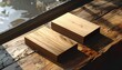 © Raden - Two light-brown wooden blocks rest on a weathered wooden surface, illuminated by natural light filtering through a window.