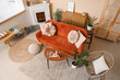 © Pixel-Shot - Fireplace, table and wicker armchair near beige wall in interior of living room