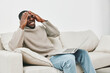 © SHOTPRIME STUDIO - A distressed young man in a cozy sweater expressing frustration while working on his laptop at home