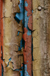 © vita - Weathered metal surface with peeling paint in vibrant colors. Close-up of a textured metal surface with layers of yellow, brown, blue peeling paint in various colors, showcasing age and decay.