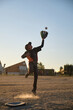 © Ladanifer - Young boy playing baseball, jumping to catch a flying ball with a glove on a dusty field