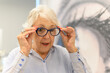 © Moon Safari - Elderly woman trying new eyeglasses feeling excited and happy with clearer eyesight and comfort after eye surgery