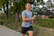 © Andromeda - Athletic guy running outdoors in the city park, healthy lifestyle concept.