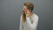 © Krakenimages.com - Man with full long beard grimaces and squints with mouth open while holding hand to ear showing earache in studio; pain.
