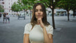© Krakenimages.com - Woman in white top lifts bare hands in puzzled shrug on busy urban street with blurred pedestrians; uncertainty.