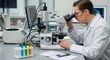© patricia - Person in white lab coat wearing safety glasses uses a microscope on a lab bench with colorful test tubes and equipment