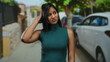 © Krakenimages.com - Young woman standing on street with trees and cars conveying contemplation and emotion in an outdoor urban environment.