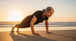 © SYATRI RAWU - Active senior woman doing push-ups on a sandy beach during a beautiful golden sunset, embodying a healthy and inspiring lifestyle