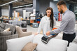 © Serhii - Client choosing sofa fabric with sales consultant