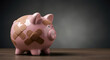 © LPhotoworks - A battered pink piggy bank covered in bandages, symbolizing financial struggle and recession, resting on a wooden surface against a dark backdrop
