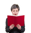 © 1STunningART - Shocked young woman looking amazed in a book, found a surprising information or an interesting text. Astonished female student reading from a red textbook isolated on transparent background