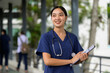© PaeGAG - Young Asian female nurse wearing scrubs holding clipboard