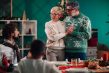 Grandparents holding hands making christmas speech to family during lunch