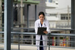 © PaeGAG - Female asian doctor checking patient data on clipboard