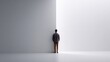 © Olga - A man is captured from the side, standing against a white background as he faces another wall behind him