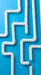 © Bhavesh - White plastic PVC water pipes arranged on blue background, plumbing concept symbolizing construction, infrastructure, drainage system, pipeline installation, and fluid management