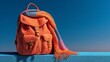 © Gasspoll - Vibrant Orange Backpack and Colorful Scarf Against a Clear Blue Sky