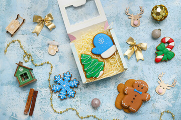 Wall Mural - Gift box with sweet gingerbread cookies, cinnamon and Christmas decorations on light blue background