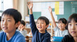© Blue Studio - 小学校の授業 手を挙げる子ども