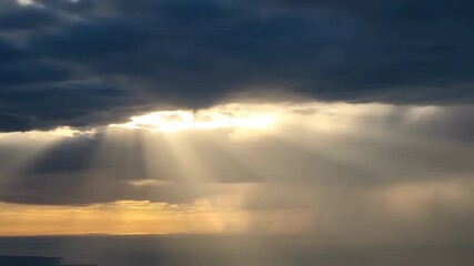 Wall Mural - Dramatic sunbeams pierce through heavy cloud cover, creating a majestic light display in the sky dark, spiritual, hope