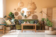 © Pixel-Shot - Comfortable sofa, table, wicker pouf and baskets with houseplants in living room