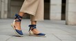 © Kapten - Womans feet in casual blue espadrilles and beige pants on pavement
