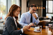 © Drazen - Happy businesswoman using smart phone in cafe.