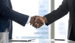 © Idah - Two business professionals shaking hands in agreement after a successful deal, close-up view.