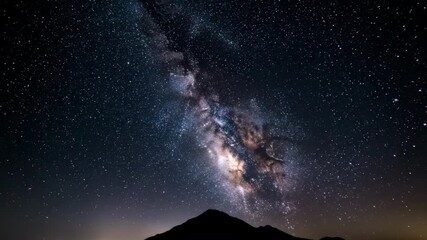 Wall Mural - Slow tilt-up shot reveals the magnificent Milky Way galaxy emerging above a distant, illuminated mountain ridge on a clear night awe, astrophotography, dramatic