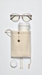 © Deviiva - Glasses, coffee cup in bag, and lid on white surface