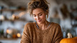 © ArtShop - Young woman smiling while carving pumpkin at home in autumn