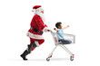 © Ljupco Smokovski - Santa Claus running and pushing a boy inside a shopping cart