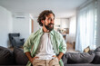 © Migma_Agency - Stylish man relaxing at home, smiling with satisfaction
