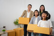 © ORG - Family moving day joyful children and parents packing boxes in a bright living room