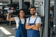 © standret - Professional tools in hand. Auto repair shop employees are working together. Man and woman