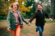 © djile - Senior couple running and laughing in autumn park