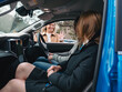 © Austockphoto - Woman waving hands to man and teenage girl inside blue car