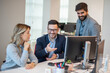 © Bojan - Business people sitting at computer discussing project during meeting in office
